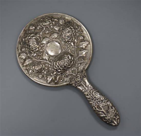 An early 20th century Chinese Export white metal hand mirror, by Hung Chong?, decorated with chrysanthemums, 25cm